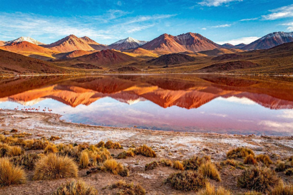 Espelho rubi surge entre montanhas isoladas da Bolívia refletindo picos andinos em águas vermelhas