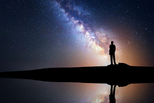 Observador contemplando reflexos das estrelas em águas cristalinas
